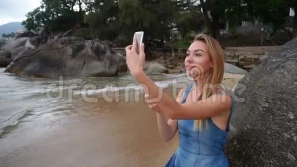 慢动作旅行博主女性在海滨的智能手机上自拍视频的预览图