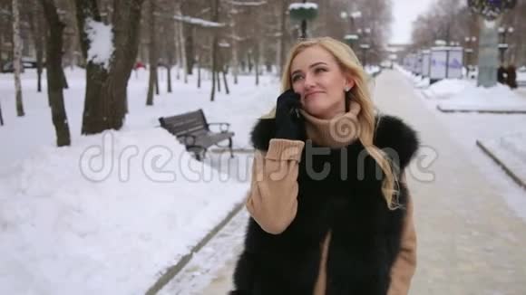 在冬季城市公园打电话的女孩视频的预览图