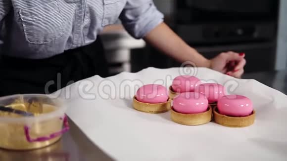 关闭一个糖果装饰粉红色糖霜甜点的镜头甜点在工作台上上面覆盖着白色视频的预览图