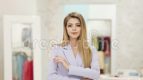 快乐的年轻漂亮的女商人站在商店里漂亮的白种人女孩穿着漂亮的西装看着镜头视频的预览图