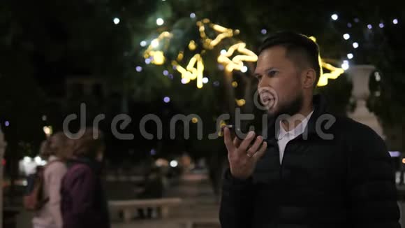男子语音识别与智能手机在公园夜间酒店酒吧室外学生男性使用留言音频帮助查找器视频的预览图