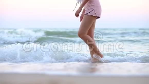 夏季假期年轻女性长腿在马尔代夫的异国沙滩上散步喷洒海水视频的预览图