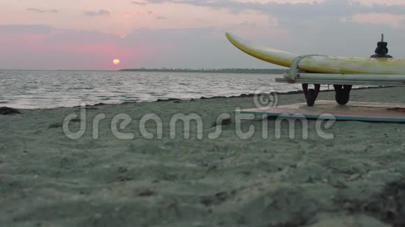 清晨地平线上的太阳低视图和海滨冲浪运动员训练装置的部分视图视频的预览图
