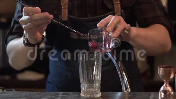 酒保在现代酒吧里准备酒精饮料在玻璃中加入蔓越莓视频的预览图