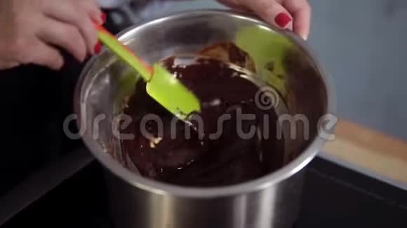 烹饪甜品的概念将巧克力放入钢碗中的水浴中与硅胶刮刀混合视频的预览图
