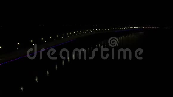 夜晚的长桥明亮的灯光和拥挤的交通倒映在水面上视频的预览图