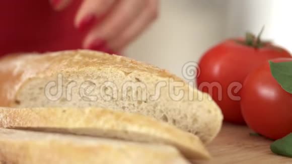 厨师的女人在一块板上切一个法式面包厨房视频的预览图
