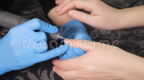 美甲师在美甲沙龙中对女孩的指甲进行修复和指甲延伸的美甲程序视频的预览图