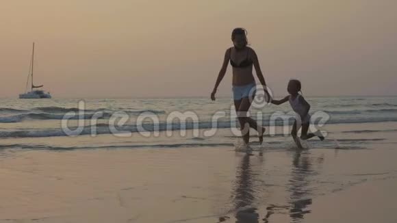 小女儿牵着手在海边奔跑的剪影视频的预览图