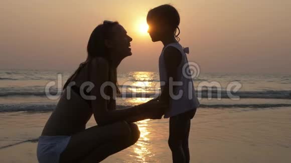 夕阳西下剪影中母亲和小女儿的深情视频的预览图