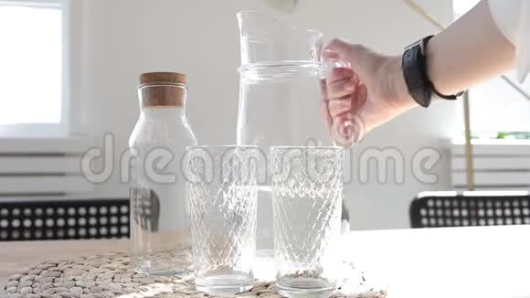 水桌子上有两个玻璃杯和一壶水视频的预览图