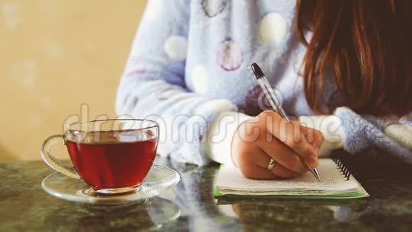 年轻女子写日记喝茶视频的预览图