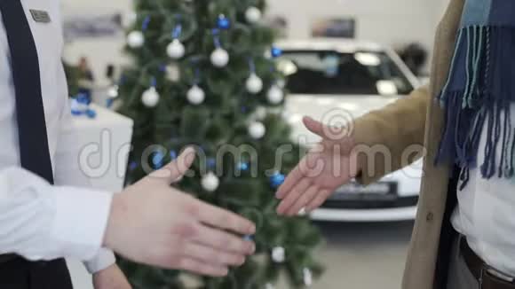 在圣诞树的背景下人们在汽车经销店握手视频的预览图