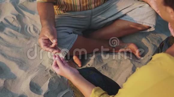 一对老夫妇在沙滩上坐在一起沉思视频的预览图