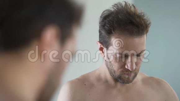 中年留胡子的男人在脸上涂上剃须泡沫早晨的仪式镜子视频的预览图