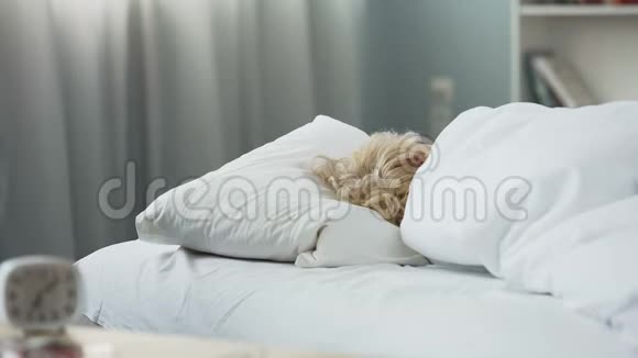 健康的睡眠躺在矫形床垫上睡觉的金发老年妇女视频的预览图