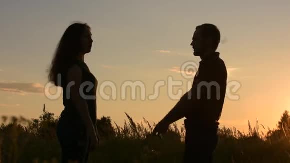 快乐的夫妇去见面在阳光直射下的侧视日落时分视频的预览图