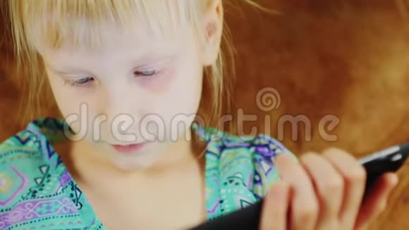 一个金发女孩在数码平板电脑上玩耍的肖像视频的预览图