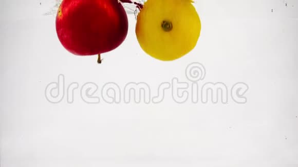 苹果柠檬和橘子在水中缓慢地落下气泡孤立的白色背景上的水果视频的预览图