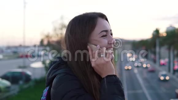 年轻漂亮的女人在城市桥上打电话视频的预览图