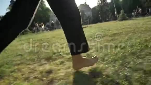 夏季白天在公园草地上奔跑的妇女的腿健康的生活方式模糊的背景视频的预览图