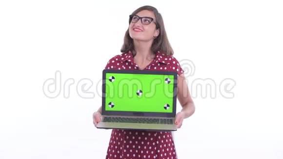 带着眼镜的快乐美女一边看着笔记本电脑一边思考视频的预览图