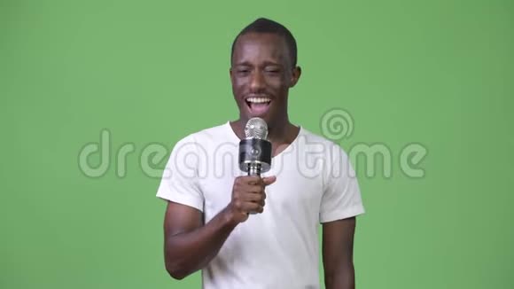 年轻快乐的非洲男人一边笑着一边讲麦克风视频的预览图