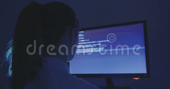 年轻女性黑客程序员晚上在数据中心的电脑上工作的肖像后景视频的预览图