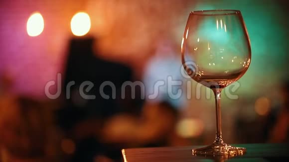 酒吧里摆着一杯空酒背景是音乐家灯光照得耀眼视频的预览图
