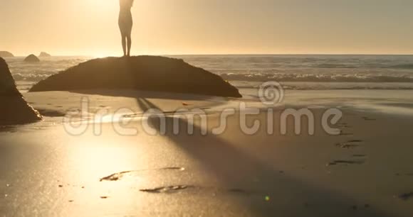 健康的女人站着手臂交叉在海滩上4k视频的预览图