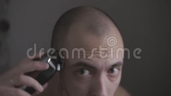 男人用电动剪刀剃头视频的预览图