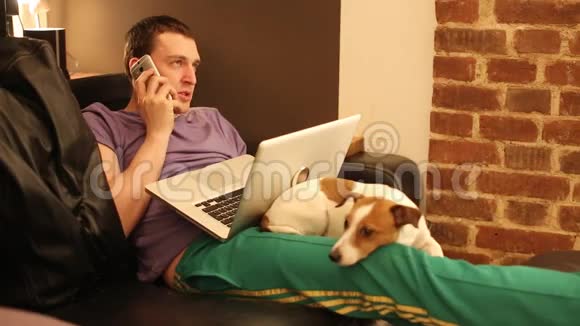 沙发上那个拿着笔记本电脑和狗的人视频的预览图