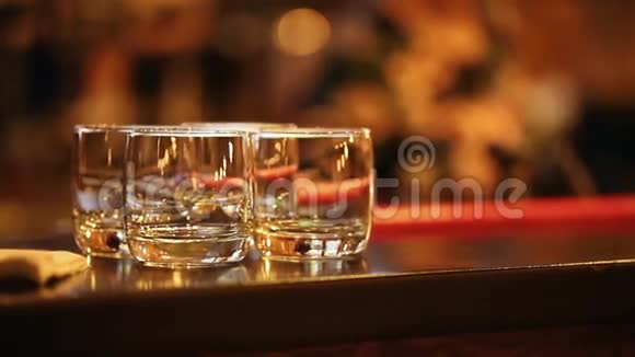 酒保把喝完的鸡尾酒放在酒吧里四只玻璃杯放在酒吧里视频的预览图