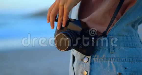 女子站在沙滩4k的老式相机视频的预览图