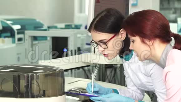 两名女性生物学家在做实验时做笔记视频的预览图