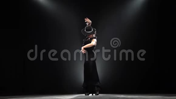 弗拉门戈女孩跳西班牙语燃烧舞黑色背景从后面发光慢动作视频的预览图