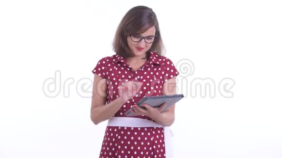 带着眼镜的快乐美女一边用数码平板电脑说话视频的预览图
