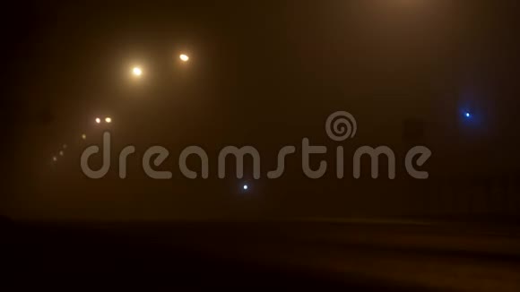 夜晚的城市街道在雾中有车的道路前灯背景视频的预览图