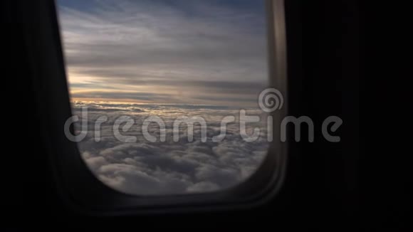 日出时天空中的云慢慢地穿过飞机的舷窗视频的预览图