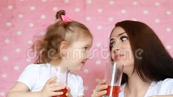 幸福的母女喝着冰沙欢欣鼓舞一位年轻女子和她的孩子的特写肖像她正在享受视频的预览图