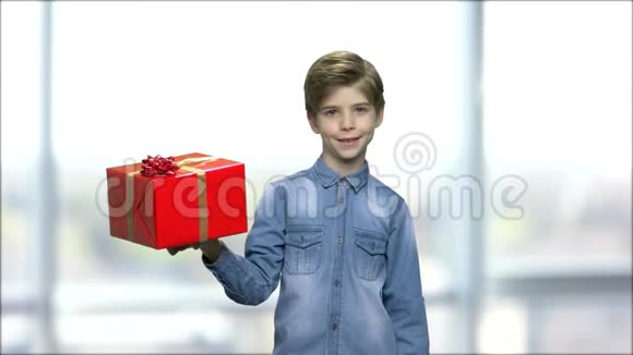 穿牛仔衬衫的男孩拿着礼品盒视频的预览图