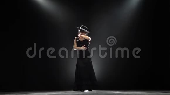 女孩跳西班牙语燃烧舞黑色背景从后面发光慢动作视频的预览图