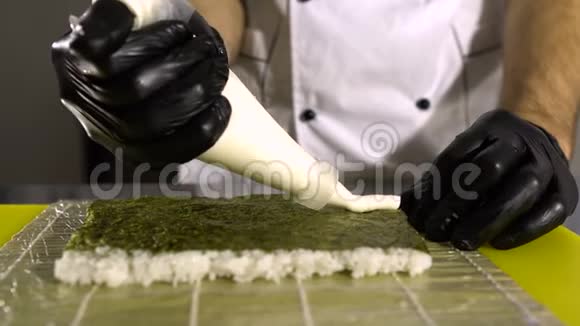 厨师的手做日本菜厨师做寿司准备寿司卷倒奶油视频的预览图