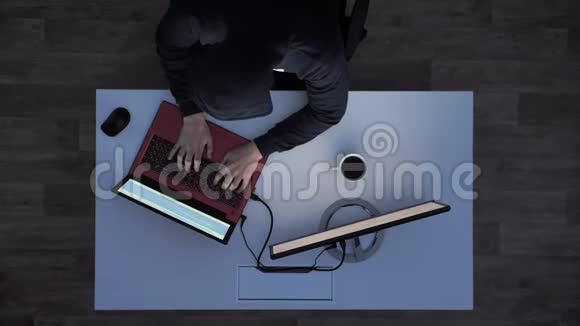 穿着黑色连帽衫的年轻人在笔记本电脑上打字然后拿着他的闪存盘当灯打开时就跑掉了视频的预览图