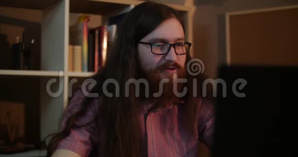 一个戴眼镜的留胡子的年轻人嘲笑电脑视频的预览图