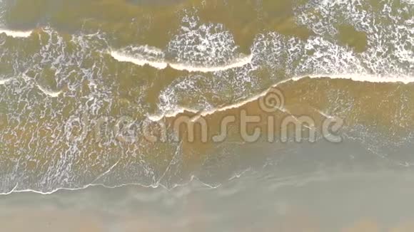 海滩空中波浪来到海岸从上面看北海的绿色水域和灰色的海沙视频的预览图