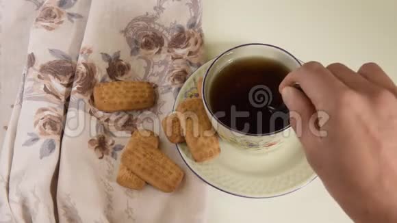 女人的手搅动着一杯茶视频的预览图