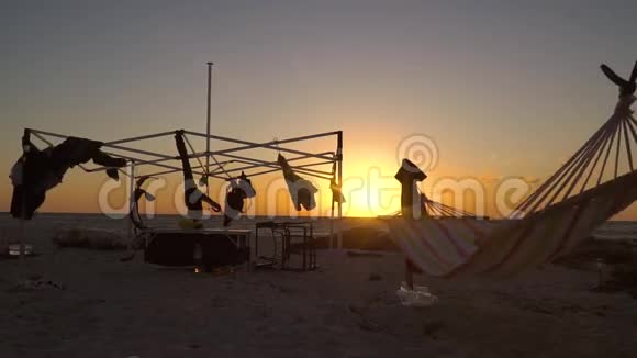 悬挂的东西和吊床在风中摆动日落时的海滩视频的预览图