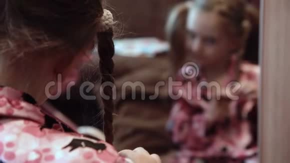 在镜子前做辫子的女孩视频的预览图