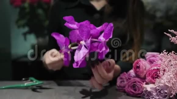 专业的女性花店用粉红色的郁金香玫瑰兰花和西兰花制作花束视频的预览图